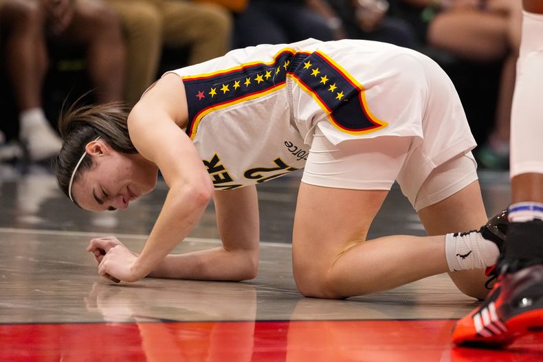 La armadora del Fever de Indiana, Caitlin Clark (22) hace un gesto luego de lesionarse en la primera mitad del juego de baloncesto de la WNBA frente al Sun de Connectitud en Indianápolis, el lunes 20 de mayo de 2024. (AP Foto/Michael Conroy)