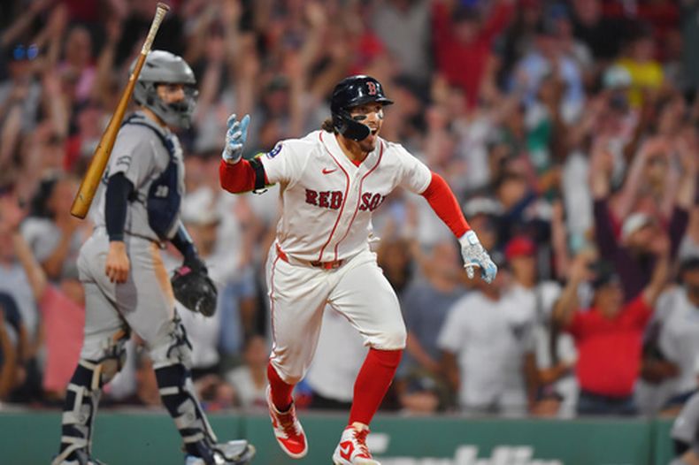 Jarren Duran, derecha, de los Medias Rojas de Boston, celebra frente al receptor de los Yankees de Nueva York, Austin Wells, izquierda, después de batear el sencillo productor con el que su equipo dejó tendidos en el campo a los Yankees en la décima entrada del juego de béisbol de Grandes Ligas del domingo 28 de junio de 2026, en Boston. (AP Foto/Steven Senne)