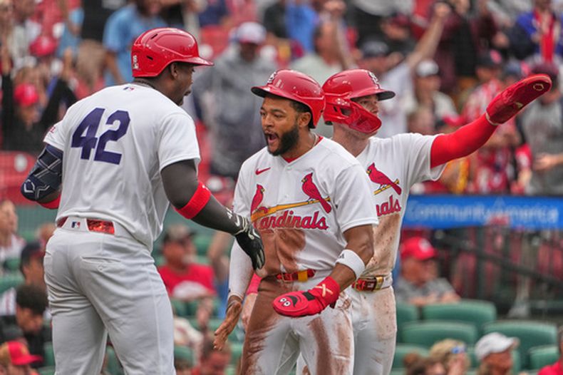 Victor Scott II (centro), Nathan Church (derecha) y Jordan Walker (izquierda) celebran una carrera de los Cardenales de San Luis ante los Guardianes de Cleveland, el miércoles 15 de abril de 2026, en San Luis. (AP Foto/Jeff Roberson)