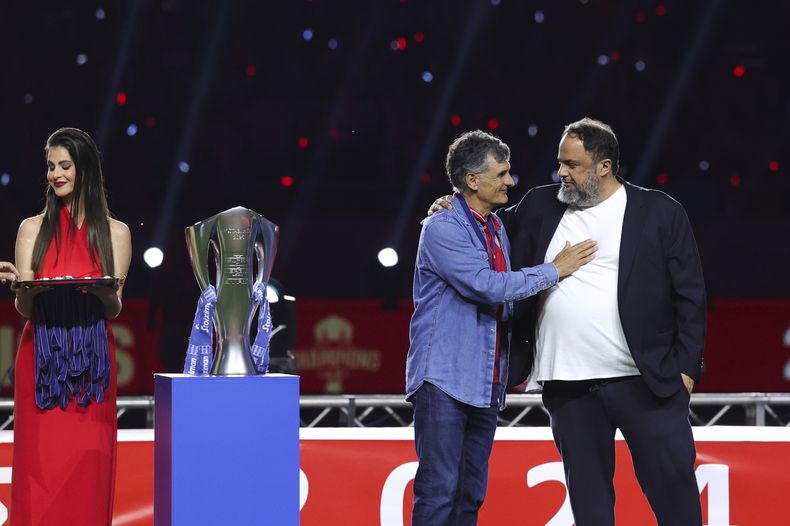 El técnico de Olympiakos José Luis Mendilibar (segundo a la derecha) recibe el saludo del presidente del club tras consagrarse campeón de la liga griega, el domingo 4 de mayo de 2025. (AP Foto/Yorgos Karahalis)
