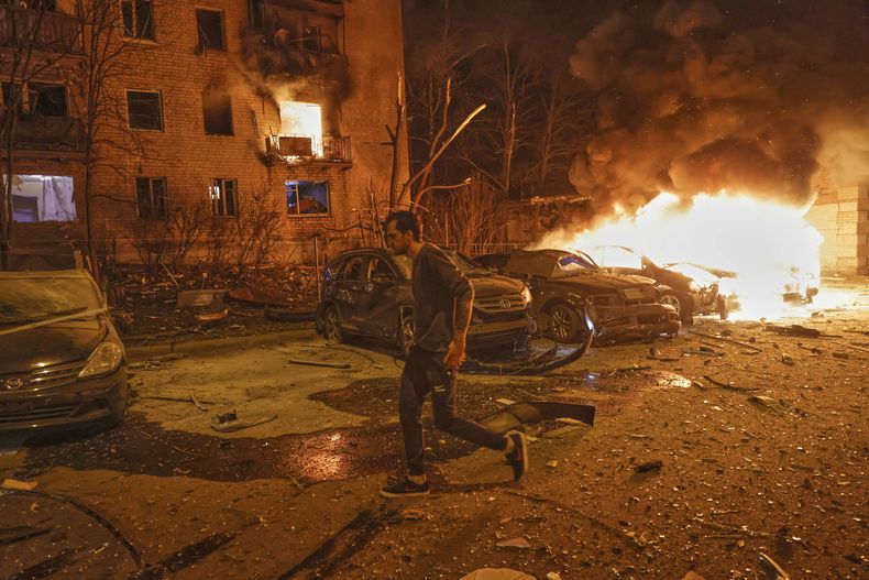 Un residente huye de un incendio tras el ataque con drones de Rusia en Járkiv, Ucrania, la noche del jueves 3 de abril de 2025. (AP Foto/Yevhen Titov)