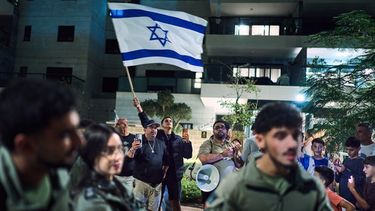 Partidarios del primer ministro de Israel, Benjamin Netanyahu (en el fondo), son separados por la policía mientras discuten con activistas de izquierda que piden un gobierno con partidos árabes en el exterior de la casa del líder de Yashar, Gadi Eisenkot, en Herzliya, Israel, el 29 de octubre de 2026. (AP Foto/David Goldman)