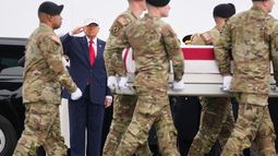 Soldados cargan un féretro que lleva los restos del reservista de la sargento de primera clase Nicole Amor, quien murió por un ataque de dron en un centro de mando de Kuwait durante la guerra de Estados Unidos e Israel en contra de Irán, mientras el presidente Donald Trump observa la llegada de los restos, el sábado 7 de marzo de 2026, en la Base de la Fuerza Aérea Dover, en Delaware. (AP Foto/Mark Schiefelbein)