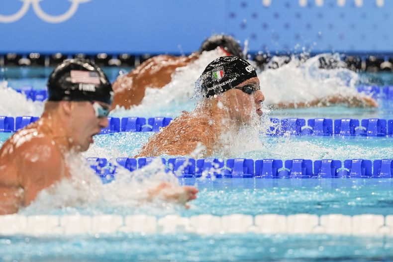 El italiano Nicolo Martinenghi (centro) compite en la final de 100 metros pecho en los Juegos Olímpicos, el domingo 28 de julio de 2024, en Nanterre, Francia (AP Foto/Martin Meissner)