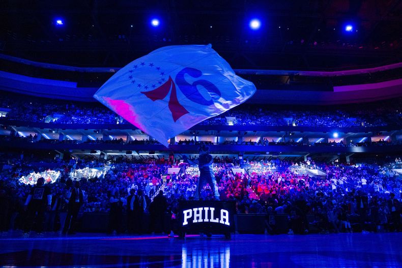 ARCHIVO - Foto de la mascota de los 76ers de Filadelfia Franklin ondeando la bandera del equipo antes del encuentro ante los Nets de Brooklyn el 14 de abril del 2024. (AP Foto/Chris Szagola, Archivo)