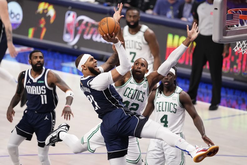 El pívot de los Mavericks de Dallas, Daniel Gafford (21), conduce hacia la canasta contra el pívot de los Celtics de Boston, Al Horford (42), durante la segunda mitad del Juego 4 de las finales de la NBA, el viernes 14 de junio de 2024, en Dallas. (AP Foto/Sam Hodde)