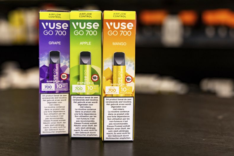 Tres versiones con distinto sabor de dispositivos de cigarrillos electrónicos desechables están en exhibición en una tienda en Bruselas el 12 de diciembre de 2024, antes de que Bélgica prohíba su venta a partir del 1 de enero de 2025. (AP Foto/Geert Vanden Wijngaert)