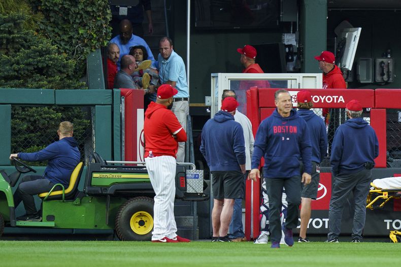 Un fanático, que cayó dentro del bullpen de Medias Rojas, es llevado por personal médico rumbo a un carrito para ser trasladado a un centro médico durante la primera entrada del juego de béisbol en contra de los Filis de Filadelfia, el viernes 5 de mayo de 2023, en Filadelfia. (AP Foto/Chris Szagola)