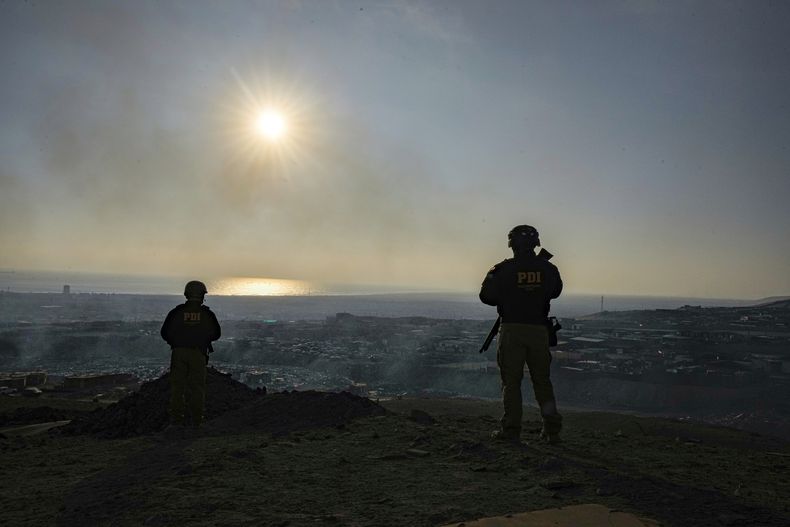 Guardaespaldas resguardan al fiscal Mario Carrera mientras observa el barrio de Cerro Chuño, un bastión de Los Gallegos, una filial del grupo criminal Tren de Aragua en el norte de Chile, el domingo 8 de junio de 2025, en Arica, Chile. (AP Foto/Esteban Felix)