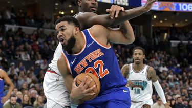 El pívot de los Knicks de Nueva York, Karl-Anthony Towns, al frente, maneja el balón contra el alero de los Grizzlies de Memphis, Jaren Jackson Jr., arriba, en la segunda mitad de un partido de baloncesto de la NBA, el viernes 28 de febrero de 2025, en Memphis, Tennessee. (AP Foto/Brandon Dill)