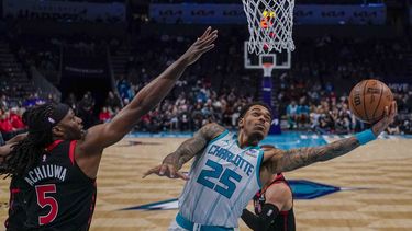 P.J. Washington (25), de los Hornets de Charlotte, se alista para encestar ante la marca defensiva de Precious Achiuwa, de los Raptors de Toronto, durante la segunda mitad del juego de baloncesto de la NBA, el viernes 8 de diciembre de 2023, en Charlotte, Carolina del Norte. (AP Foto/Chris Carlson)