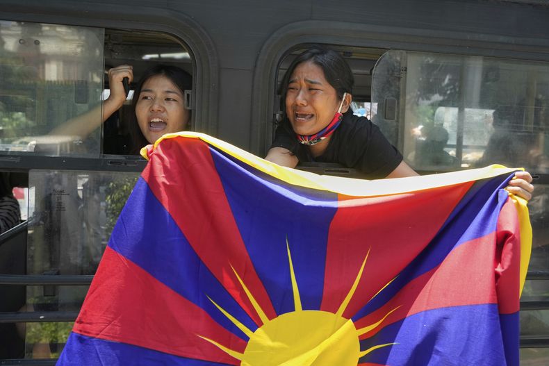 Tibetanos exiliados gritan consignas desde un autobús después de ser detenidos y llevados a una estación de policía durante una protesta contra la visita del ministro de Relaciones Exteriores chino, Wang Yi, a India, en Nueva Delhi, India, el martes 19 de agosto de 2025. (AP Foto/Manish Swarup)