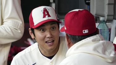 El japonés Shohei Ohtani, de los Angelinos de Los Ángeles, habla con el mexicano Benji Gil, coach de infield, antes del duelo del miércoles 26 de abril de 2023, ante los Atléticos de Oakland (AP Foto/Mark J. Terrill)