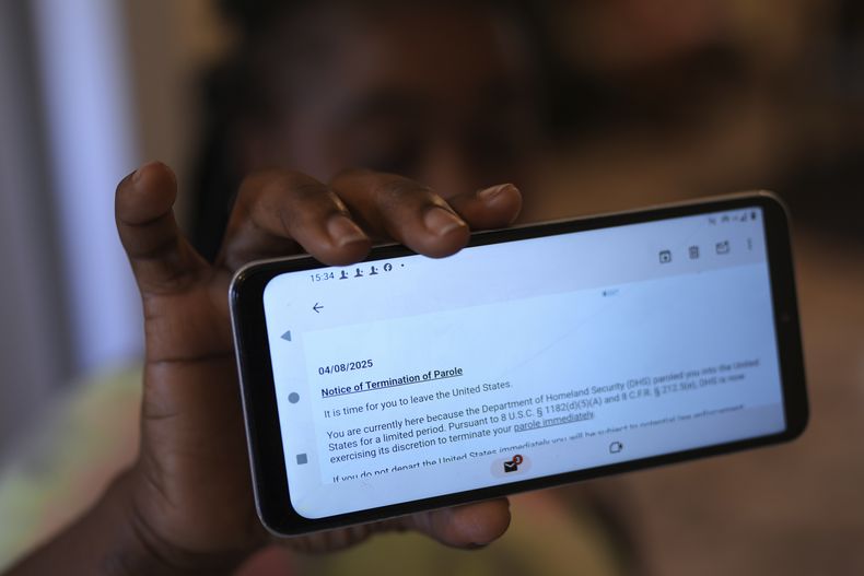 Nicole, una inmigrante haitiana que trabaja en una planta procesadora de carne, muestra un email en el que se le anuncia la cancelación de su permiso humanitario, el domingo 13 de abril de 2025, en Dumas, Texas. (AP Foto/Eric Gay)