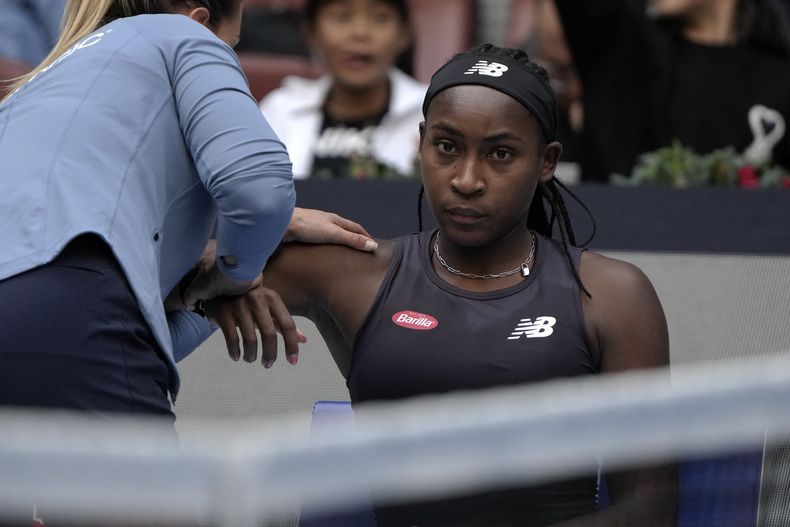 Coco Gauff recibe tratamiento en el hombro durante la semifinal del Abierto de China contra Iga Swiatek, el sábado 7 de octubre de 2023, en Beijing. (AP Foto/Andy Wong)