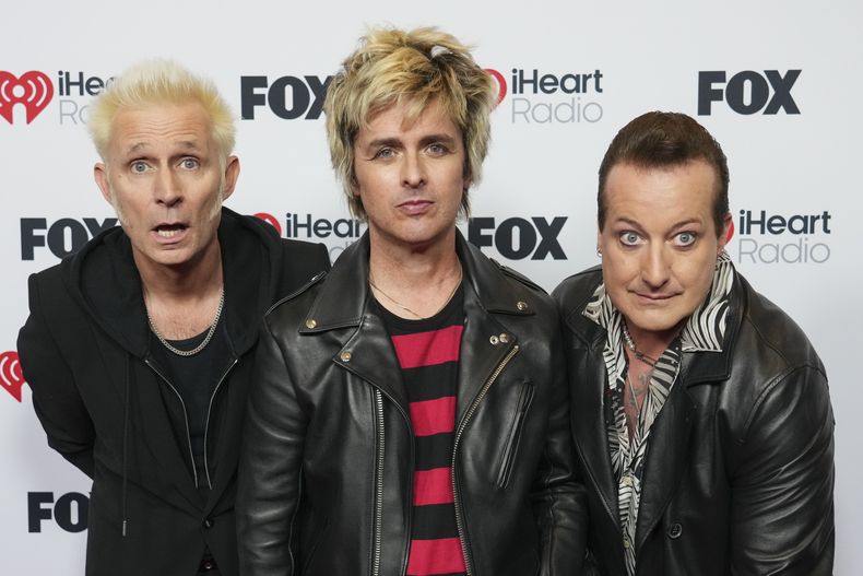 Mike Dirnt, de izquierda a derecha, Billie Joe Armstrong y Tre Cool de Green Day llegan a los iHeartRadio Music Awards, el lunes 17 de marzo de 2025, en el Dolby Theatre de Los Ángeles. (Foto Jordan/Invision/AP)