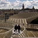 Una pareja camina por uno de los corredores del Metropol Parasol, desde donde se ve la ciudad antigua y la Catedral de Sevilla con La Giralda en España, el 18 de noviembre de 2012. La Academia Latina de la Grabación anunció el 4 de mayo de 2023 que la 24a ceremonia del Latin Grammy se celebrará el 16 de noviembre en esta ciudad del sur de España. (Foto AP/Emilio Morenatti, archivo)