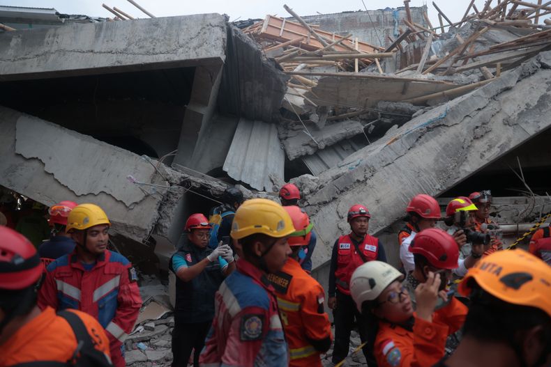 Rescatistas buscan víctimas en el lugar donde se derrumbó un edificio en construcción en un internado islámico en Sidoarjo, Java Oriental, Indonesia, el martes 30 de septiembre de 2025. (AP Foto/Trisnadi)