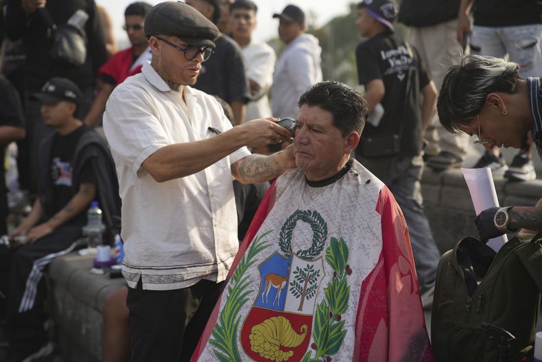 Un barbero corta el pelo durante una protesta contra la extorsión y la inseguridad en Lima, Perú, el miércoles 4 de diciembre de 2024. (Foto AP/Guadalupe Pardo)