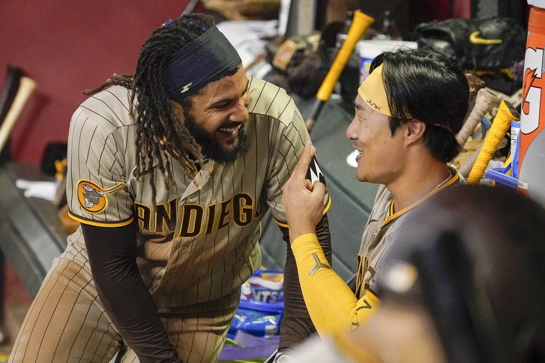 El dominicano Fernando Tatis Jr. ríe con el surcoreano Ha-Seong Kim, su compañero en los Padres de San Diego, el viernes 11 de agosto de 2023, en el duelo ante los Diamondbacks de Arizona (AP Foto/Darryl Webb)
