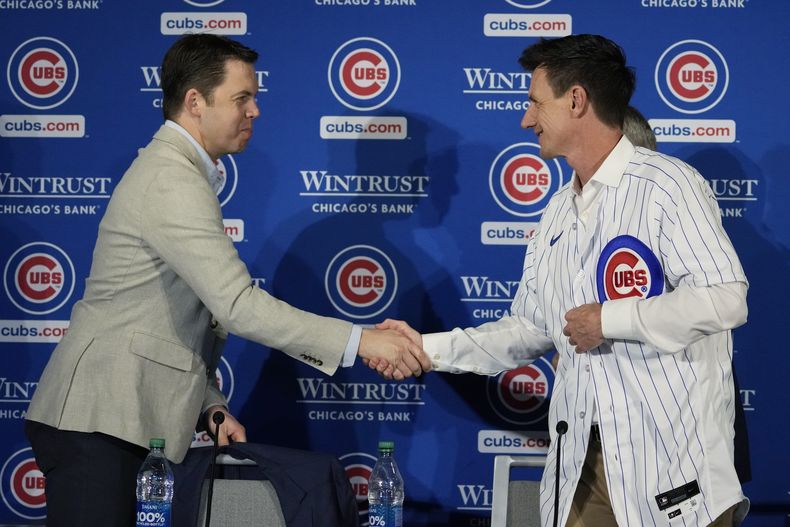 El gerente general de los Cachorros de Chicago Carter Hawkins le da la mano al nuevo mánager del equipo Craig Counsell durante la conferencia de prensa en su presentación el lunes 13 de noviembre del 2023. (AP Foto/Nam Y. Huh)