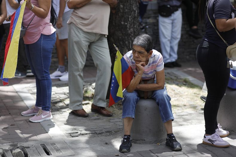 Una mujer espera junto a sus compañeros simpatizantes la llegada de la líder opositora María Corina Machado, en Caracas, Venezuela, el sábado 3 de agosto de 2024. (Foto AP/Cristian Hernández)