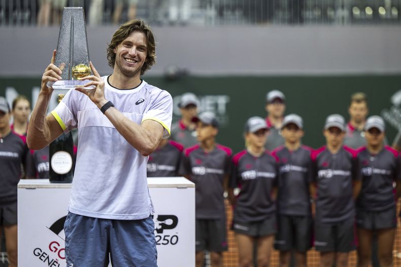 El chileno Nicolás Jarry posa con el trofeo tras vencer al búlgaro Grigor Dimitrov en la final del Abierto de Ginebra el sábado 27 de mayo del 2023. (Martial Trezzini/Keystone via AP)