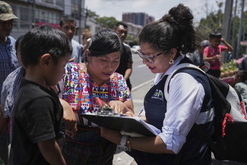 Un familiar de un menor de edad deportado desde Estados Unidos revisa la lista de deportados afuera del Aeropuerto Internacional La Aurora en Ciudad de Guatemala el 31 de agosto del 2025. (AP foto/Moises Castillo)
