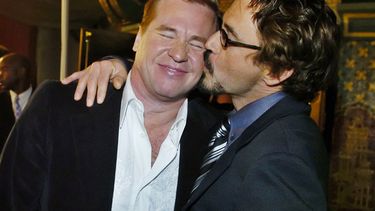 ARCHIVO - Val Kilmer, izquierda, es besado por su compañero de reparto de Kiss Kiss Bang Bang Robert Downey Jr. en la premiere de la película en Los Angeles el 18 de octubre de 2005. (Foto AP/Chris Pizzello, archivo)