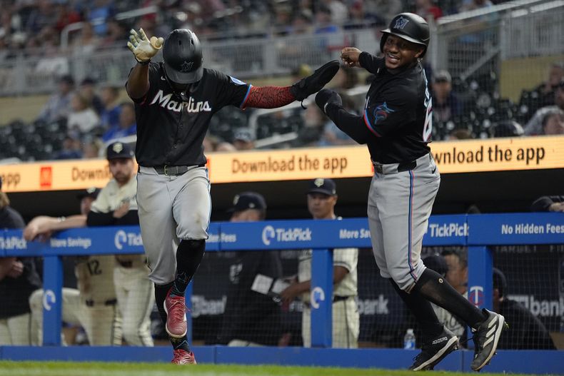 El dominicano Otto López (izquierda) y Xavier Edwards, de los Mellizos de Minnesota, festejan tras anotar en la 13ra entrada del juego ante los Mellizos de Minnesota, el jueves 26 de septiembre de 2024 (AP Foto/Abbie Parr)