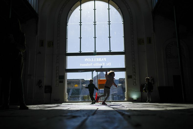 Niños juegan mientras sus familiares votan en las elecciones primarias en un colegio electoral en Buenos Aires, Argentina, el domingo 13 de agosto de 2023. (Foto AP/Natacha Pisarenko)