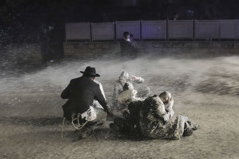 La policía utiliza cañones de agua para dispersar a hombres judíos ultraortodoxos que bloquean una calle durante una protesta contra el reclutamiento en el ejército, el domingo 30 de junio de 2024, en Jerusalén. (AP Foto/Mahmoud Illean)