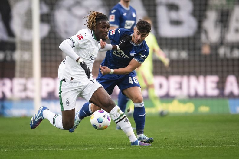 Manu Kone del Borussia Mönchengladbach y Umut Tohumcu del Hoffenheim pelean por el balón durante el encuentro de la Bundesliga el sábado 2 de diciembre del 2023. (Marius Becker/dpa via AP)