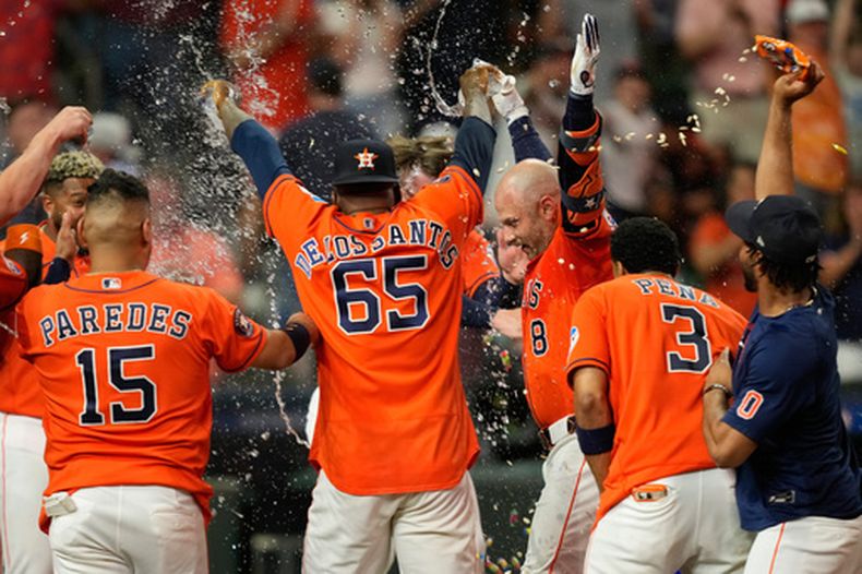 Christian Walker (8), de los Astros de Houston, celebra con sus compañeros tras conectar el cuadrangular decisivo de tres carreras frente a los Marineros de Seattle, en el juego de béisbol de Grandes Ligas del viernes 14 de agosto de 2026, en Houston. (AP Foto/David J. Phillip)
