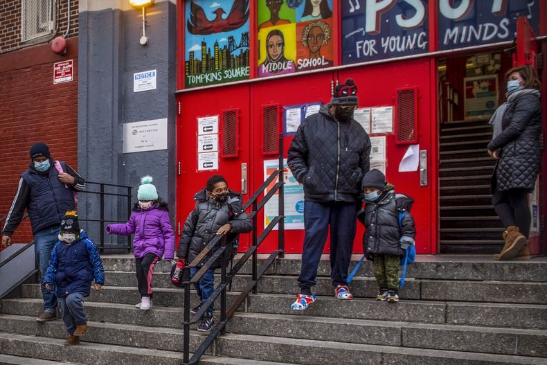 ARCHIVO – Varios niños y sus tutores salen de la escuela P.S. 64 en el vecindario de East Village, en Manhattan, el martes 21 de diciembre de 2021, en Nueva York. (AP Foto/Brittainy Newman, Archivo)