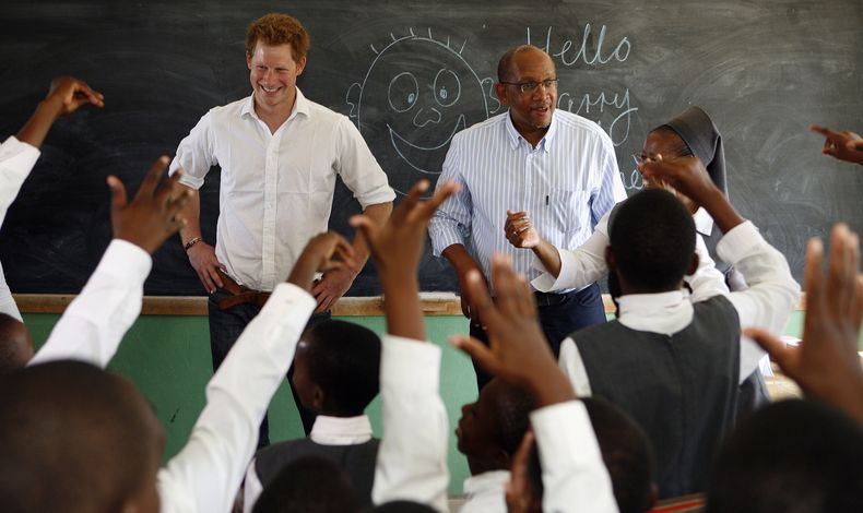 ARCHIVO - El príncipe Enrique de Gran Bretaña, a la izquierda, acompañado por el príncipe Seeiso de Lesotho, se reúne con alumnos de una clase durante su visita al Centro Kananelo para Sordos en las afueras de Maseru, Lesotho, el miércoles 27 de febrero de 2013. (Foto AP/Themba Hadebe, archivo)