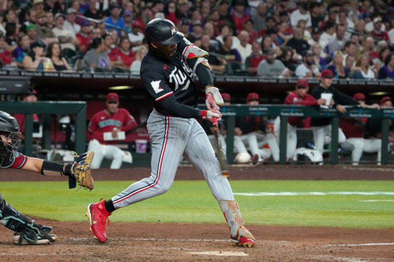Byron Buxton (derecha), de los Mellizos de Minnesota, conecta un grand slam en la quinta entrada contra los Diamondbacks de Arizona durante un partido de béisbol, el sábado 20 de junio de 2026, en Phoenix. (Foto AP/Darryl Webb)
