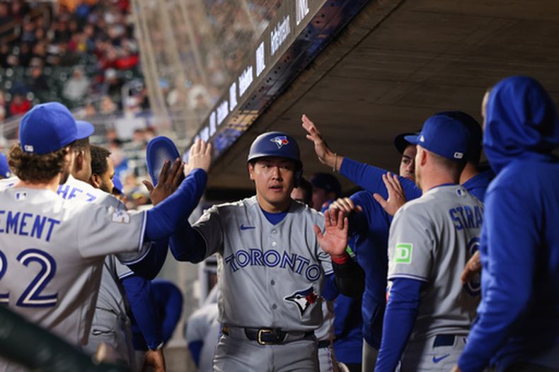 Kazuma Okamoto, centro, de los Azulejos de Toronto, celebra en el dugout después de anotar con un sencillo de Yohendrick Pinango, durante la séptima entrada del juego de béisbol de Grandes Ligas contra los Mellizos de Minnesota, el viernes 1 de mayo de 2026, en Minneapolis. (AP Foto/Stacy Bengs)