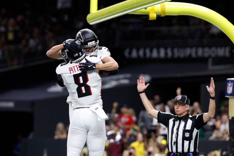 David Sills V (87), de los Falcons de Atlanta, abraza a su compañero Kyle Pitts Sr. (8) después de anotar un touchdown frente a los Saints de Nueva Orleans en la primera mitad del partido de la NFL, el domingo 23 de noviembre de 2025, en Nueva Orleans. (AP Foto/Butch Dill)
