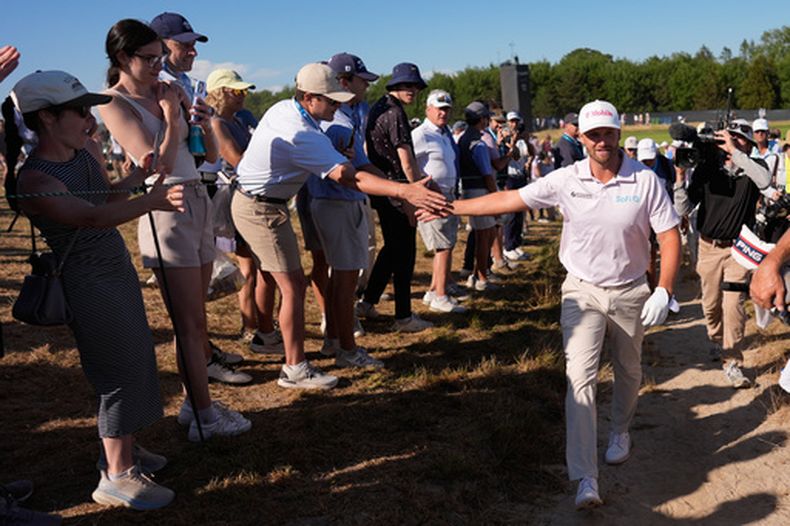 Wyndham Clark saluda a un aficionado durante la última ronda del Abierto de Estados Unidos de Golf, en el Club de Golf en Shinnecock Hills, el domingo 21 de junio de 2026, en Southampton, Nueva York. (AP Foto/George Walker IV)
