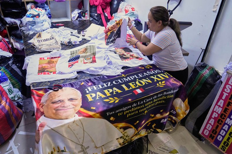 Vicky Quiñones exhibe camisetas a la venta del papa León XIV con motivo de su cumpleaños en Lima, Perú, el lunes 14 de septiembre de 2026. (Foto AP/Martín Mejía)