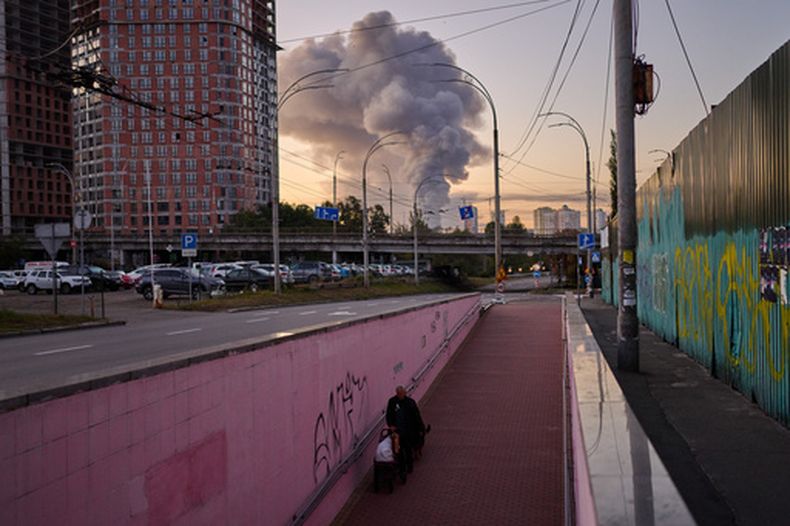 Un hombre camina por un paso subterráneo mientas el humo se eleva al fondo tras un ataque de misil ruso en Kiev, Ucrania, la mañana del martes 8 de septiembre de 2026. (AP Foto/Francisco Seco)