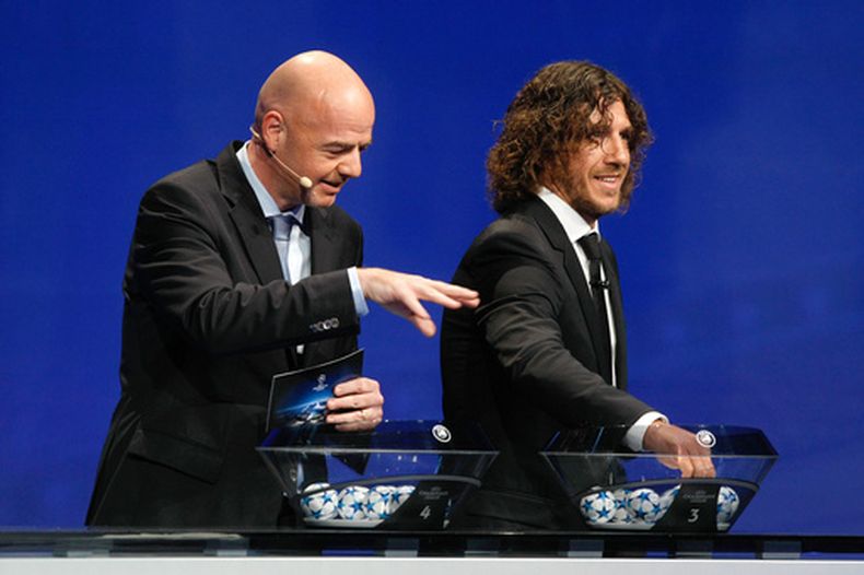 ARCHIVO - Foto del 27 de agosto del 2015, el secretario general de la UEFA Gianni Infatino durante el sorteo de la Liga de Campeones acompañado del exjugador del Barcelona Carles Puyol. (AP Foto/Claude Paris, Archivo)