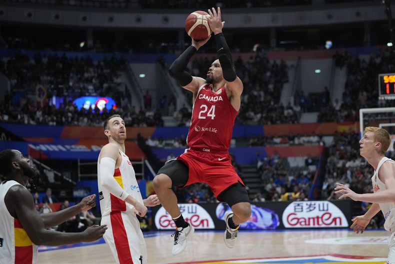 El alero canadiense Dillon Brooks lanza el balón sobre Víctor Claver de España durante el encuentro de la segunda ronda de la Copa Mundial de baloncesto el domingo 3 de septiembre del 2023. (AP Foto/Achmad Ibrahim)