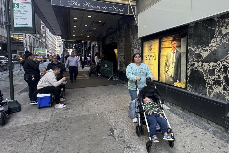 Maribel Hidalgo, una inmigrante venezolana de 23 años, empuja un cochecito que lleva a su hijo, Daniel, de 2 años, afuera del refugio de inmigración del Hotel Roosevelt en Nueva York el miércoles 6 de noviembre de 2024. (AP Foto/Cedar Attanasio)