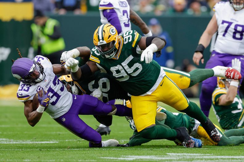 ARCHIVO - Aaron Jones Sr. (33), running back de los Vikings de Minnesota, es golpeado por Devonte Wyatt (95), tackle defensivo de los Packers de Green Bay, durante el partido de la NFL del 23 de noviembre de 2025, en Green Bay, Wisconsin. (AP Foto/Matt Ludtke, Archivo)
