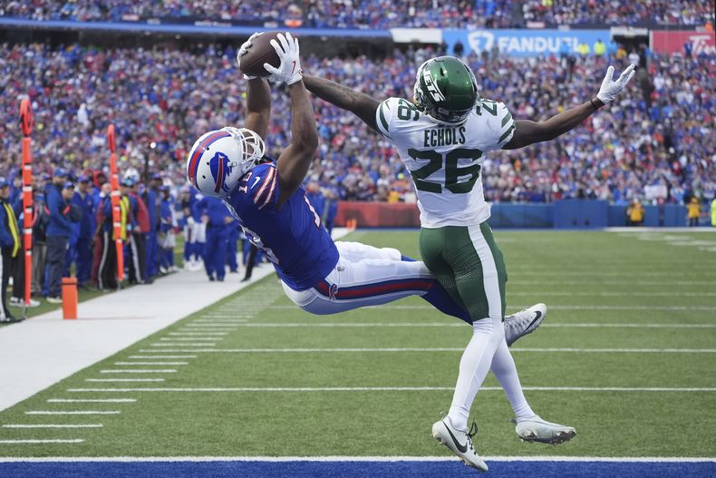 Amari Cooper (18), wide receiver de los Bills de Buffalo, atrapa un pase de touchdown frente al cornerback Brandin Echols (26), de los Jets de Nueva York, durante la segunda mitad del partido de la NFL del domingo 29 de diciembre de 2024, en Orchard Park, Nueva York. (AP Foto/Gene J. Puskar)