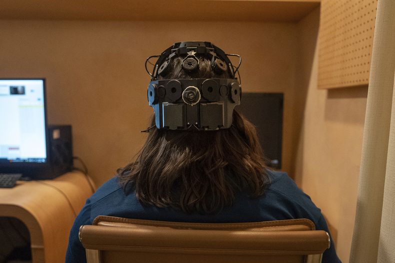 Emily Hollenbeck, paciente de terapia de estimulación cerebral profunda, muestra un dispositivo EEG que registra la actividad cerebral mientras ella ve videos cortos en el Q-Lab, el 20 de diciembre de 2023, de Mount Sinai, en Nueva York. (AP Foto/Mary Conlon)