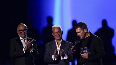El director ejecutivo de La Academia Latina de la Grabación, Manuel Abud, izquierda, y Alejandro Sanz, centro, entregan el Premio de la Presidencia a Antonio Banderas durante la 24a entrega anual del Latin Grammy en Sevilla, España, el 16 de noviembre de 2023. (Foto Jose Breton/Invision/AP)