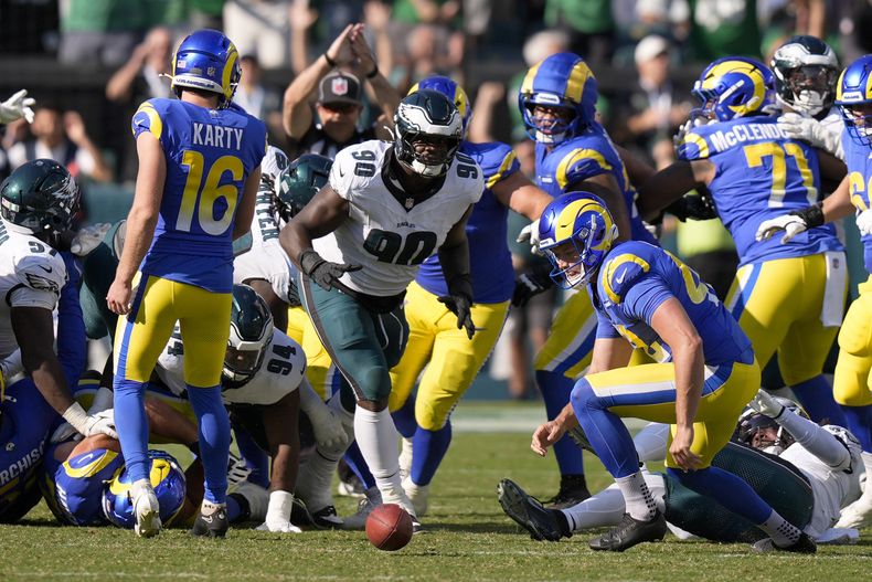 Jordan Davis (90), tackle defensivo de los Eagles de Filadelfia, se prepara para recoger el balón después de bloquear un intento de gol de campo de Joshua Karty (16), pateador de los Rams de Los Ángeles, y devolverlo hasta la zona de anotación para un touchdown mientras el tiempo expira, durante la segunda mitad del partido de la NFL del domingo 21 de septiembre de 2025, en Filadelfia. (AP Foto/Chris Szagola)